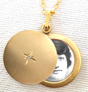 Round Slide Locket . Closeup showing open locket  with north star in center and photo inside